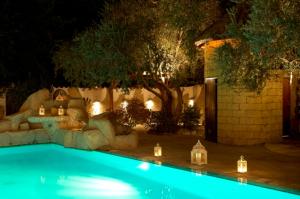 a swimming pool with lights in a yard at night at Cleopatra Hotel in Nicosia