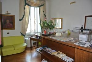 ローマにあるル·プティ·リアルのデスクと緑の椅子が備わるオフィス