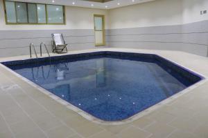 a swimming pool with blue water in a room at Marina Tower in Juffair