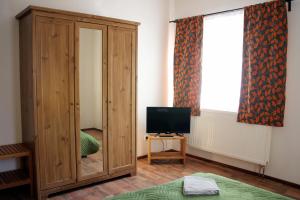 1 dormitorio con armario de madera y TV en Kremenisko II, en Banská Štiavnica