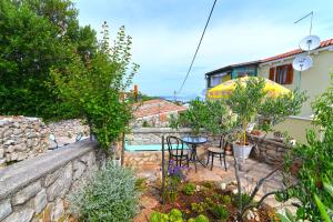 a garden with a table and chairs and a building at Roberto 3 in Veli Lošinj