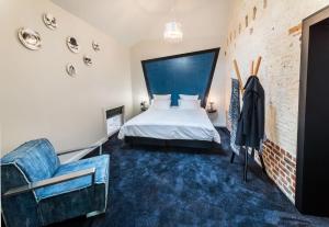 アラスにあるLe Pavillon du Golf d'Arrasのベッドと椅子付きのホテルルーム