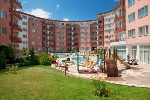 a playground in front of a large apartment building at Privilege Beach Apartments in Sveti Vlas