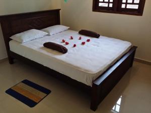 Una cama con rosas rojas en un dormitorio. en Dumi House, en Weligama