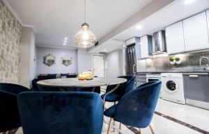 馬德里的住宿－Chamberí I，厨房以及带圆桌和蓝色椅子的用餐室。