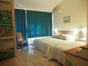 Habitación de hotel con 2 camas y ventana en Hotel Le Tre Isole, en Magione