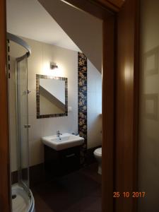 卡尔帕奇Dworek Karpacz的浴室里有洗手池、马桶和镜子。