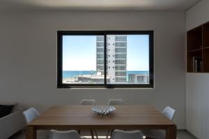 a dining room with a table and a view of the ocean at Modern 2-BR in Carmel Market by HolyGuest in Tel Aviv