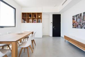 a dining room with a wooden table and chairs at Modern 2-BR in Carmel Market by HolyGuest in Tel Aviv