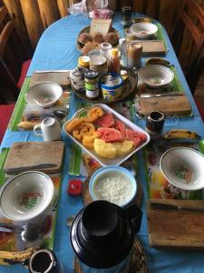 einen Tisch mit einem blauen Tischtuch mit Essen drauf in der Unterkunft Amasiko Homestay Lake Bunyonyi in Kabale