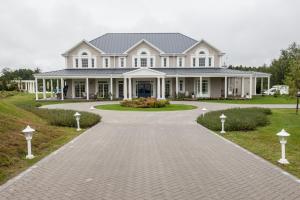 a large white house with a driveway at Rezydencja Miętowe Wzgórza Mansion House in Zakroczym