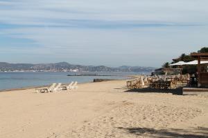 a beach with chairs and tables and the water at Villa Alizée B&B in Saint-Tropez +11 photos