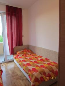ein Schlafzimmer mit einem Bett in einem Zimmer mit einem Fenster in der Unterkunft Debora Apartment in Vrnjačka Banja