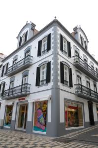 un gran edificio blanco con ventanas de contraventanas negras en Edificio Charles 204, en Funchal