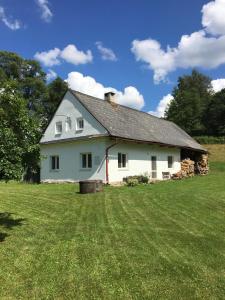 una casa blanca en un campo con césped en Chalupa u Potoka Vikantice, en Vikantice