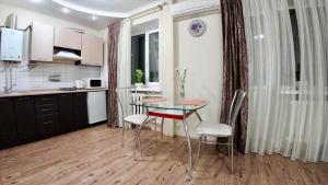 a kitchen and dining room with a table and chairs at Myru Apartment in Chernihiv