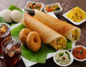 einen Teller mit Brot und anderen Lebensmitteln in der Unterkunft Hotel Fantacee in Navi Mumbai