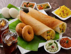 een bord met brood en andere voedingsmiddelen bij Hotel Fantacee in Navi Mumbai