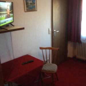 een kamer met een tafel, een stoel en een televisie bij Hotel-Restaurant Hellmann in Schwarzenbruck