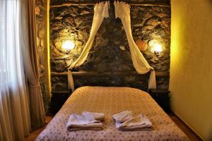 a bedroom with a bed with two towels on it at Zeidoro in Palaios Agios Athanasios