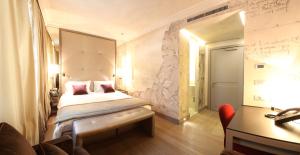 a hotel room with a bed, desk and a television at Palazzo Righini in Fossano