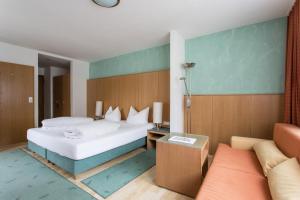 a hotel room with a bed and a couch at Hotel Das Zentrum in Sölden