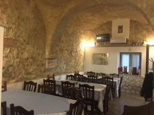 a restaurant with tables and chairs in a stone wall at Tenuta Ferrara in Altavilla Silentina