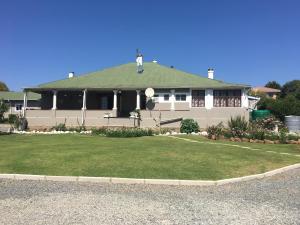 a large white house with a green roof at Rest Assured Guest House & Conference Kokstad in Kokstad