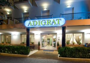 un panneau indiquant un immeuble d'appartements la nuit dans l'établissement Hotel Adigrat, à Riccione