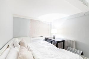 ロンドンにあるComfy 2 bed flat with perfect location in Notting Hillの白いベッドルーム(ベッド1台、デスク付)