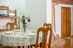 Fairy Glen في كونور: طاولة غرفة الطعام مع إناء من الزهور عليها