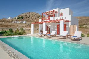 a villa with a swimming pool in front of a house at Natura Villas in Naxos in Mikri Vigla