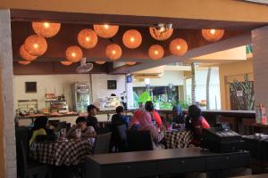 a group of people sitting at tables in a restaurant at Marose Gold Coast Morib in Morib