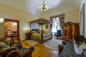 1 dormitorio con 1 cama, mesa y sillas en Prónay-kastély en Alsópetény
