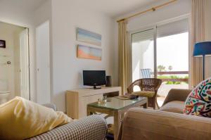 un soggiorno con divano e TV di Apartamento Moran a Conil de la Frontera