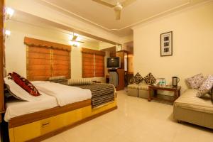 a bedroom with a bed and a couch and a tv at The C Park Inn Karol Bagh Homely Atmosphere in New Delhi +14 photos