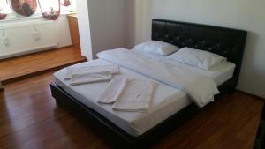 un grande letto con due asciugamani bianchi sopra di M&F APARTAMENT JEPILOR a Braşov