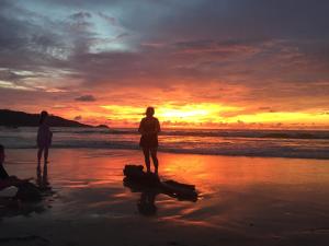 un gruppo di persone in piedi sulla spiaggia al tramonto di Freedom Hotel a Patong Beach