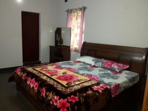 een slaapkamer met een bed met een bloemdekbed bij Holidays and Celebrations in Kodaikānāl