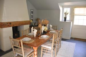 a dining room with a wooden table and chairs at Mews Cottage in Cury