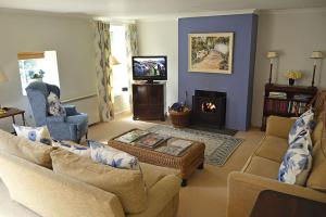 a living room with two couches and a fireplace at Mews Cottage in Cury