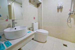 La salle de bains est pourvue d'un lavabo, de toilettes et d'une douche. dans l'établissement Pai Hotel Nanchang Honggu Beach Fenghe Avenue Cuiyuan Road Subway, à Nanchang