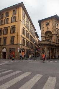 une personne à vélo dans une rue à côté d'un bâtiment dans l'établissement Le Tre Lune Suites, à Florence