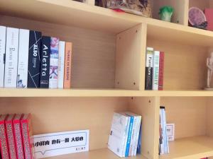 Pai Hotel Gannan Corperation Bus Company في Te-wu-lu-shih: رف كتاب ممتلئ بالكثير من الكتب