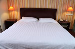 เตียงในห้องที่ Pai Hotel Zhanjiang Xuwen