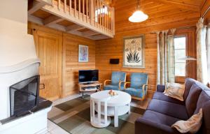 a living room with a couch and a fireplace at Holiday Club Ähtäri Cottages in Ähtäri