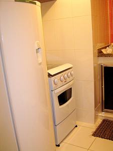 a stove in a kitchen next to a refrigerator at Studio Copacabana in Rio de Janeiro