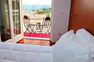 a bedroom with a bed and a view of a balcony at Hotel La Dimora di Piazza Carmine in Ragusa