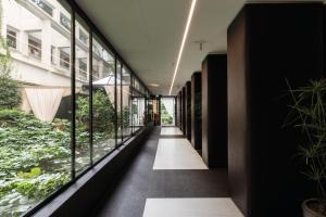 an internal corridor of a building with glass windows at Hotel Manin in Milan