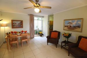 Wilger Guesthouse في سنتوريون: غرفة معيشة مع طاولة وكراسي ومروحة سقف